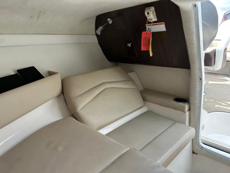 Slide: The Image of 2016 Regal 2250 Cuddy cabin interior with beige seating and storage compartment. - 16