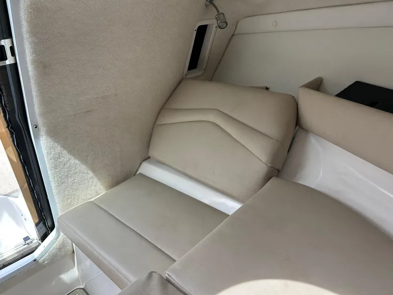 Slide: The Image of 2016 Regal 2250 Cuddy cabin interior with beige seating and wall paneling. - 17