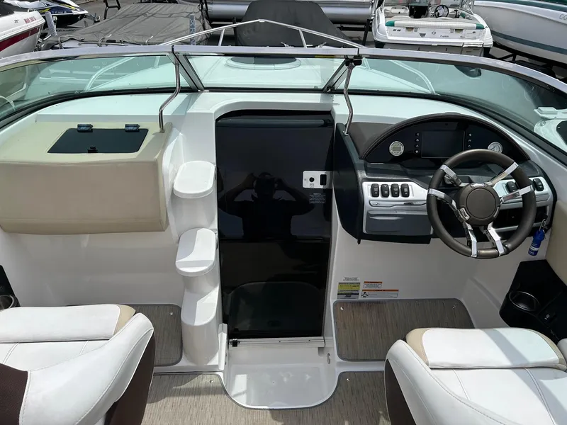 Slide: The Image of 2016 Regal 2250 Cuddy boat interior with steering wheel and seating area. - 19