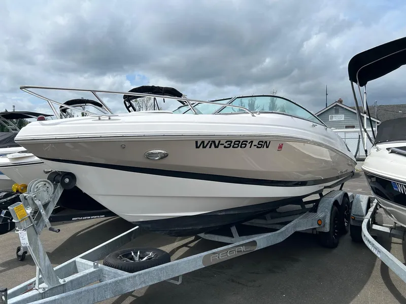 Slide: The Image of 2016 Regal 2250 Cuddy boat on trailer, parked outdoors under cloudy sky. - 2