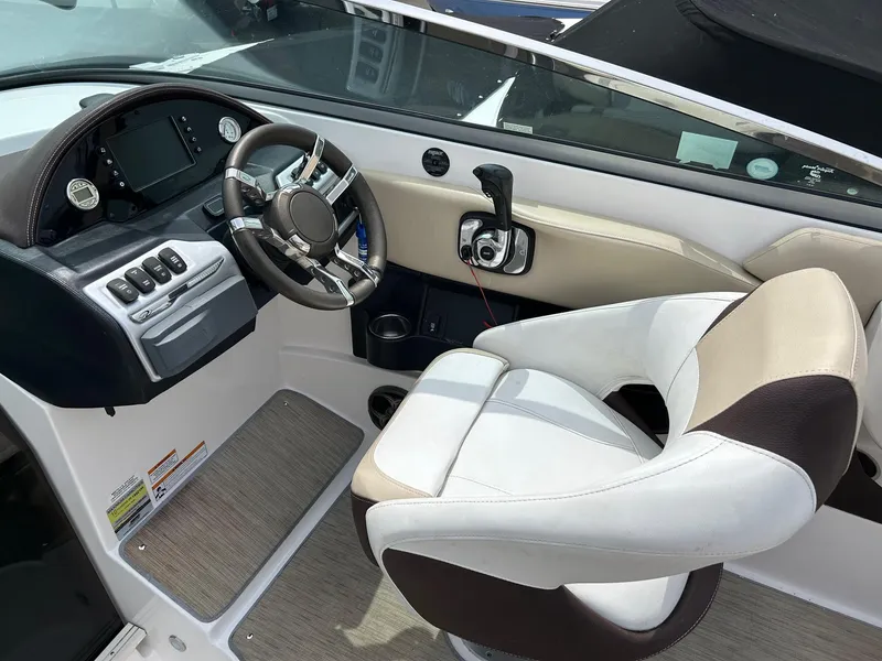 Slide: The Image of Interior of 2016 Regal 2250 Cuddy boat showing steering wheel and captain's seat. - 21