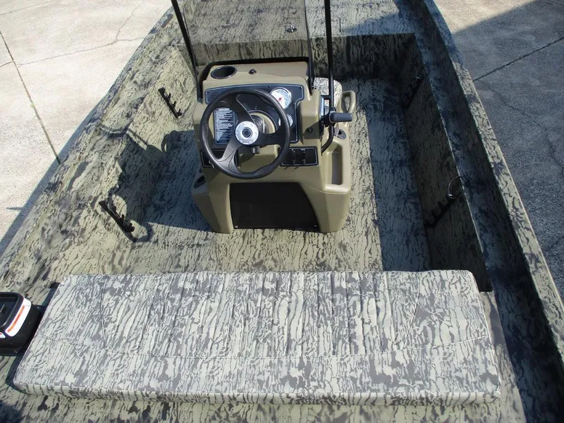 Slide: The Image of 2026 Tracker GRIZZLY® 1860 CC boat interior with camouflage design and steering console. - 5