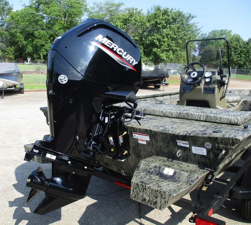 Slide: The Image of 2026 Tracker GRIZZLY® 1860 CC boat with Mercury outboard motor, parked outdoors. - 8