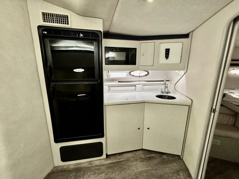 Slide: The Image of 1997 Regal Commodore 402 yacht interior kitchen with fridge, microwave, and sink. - 12