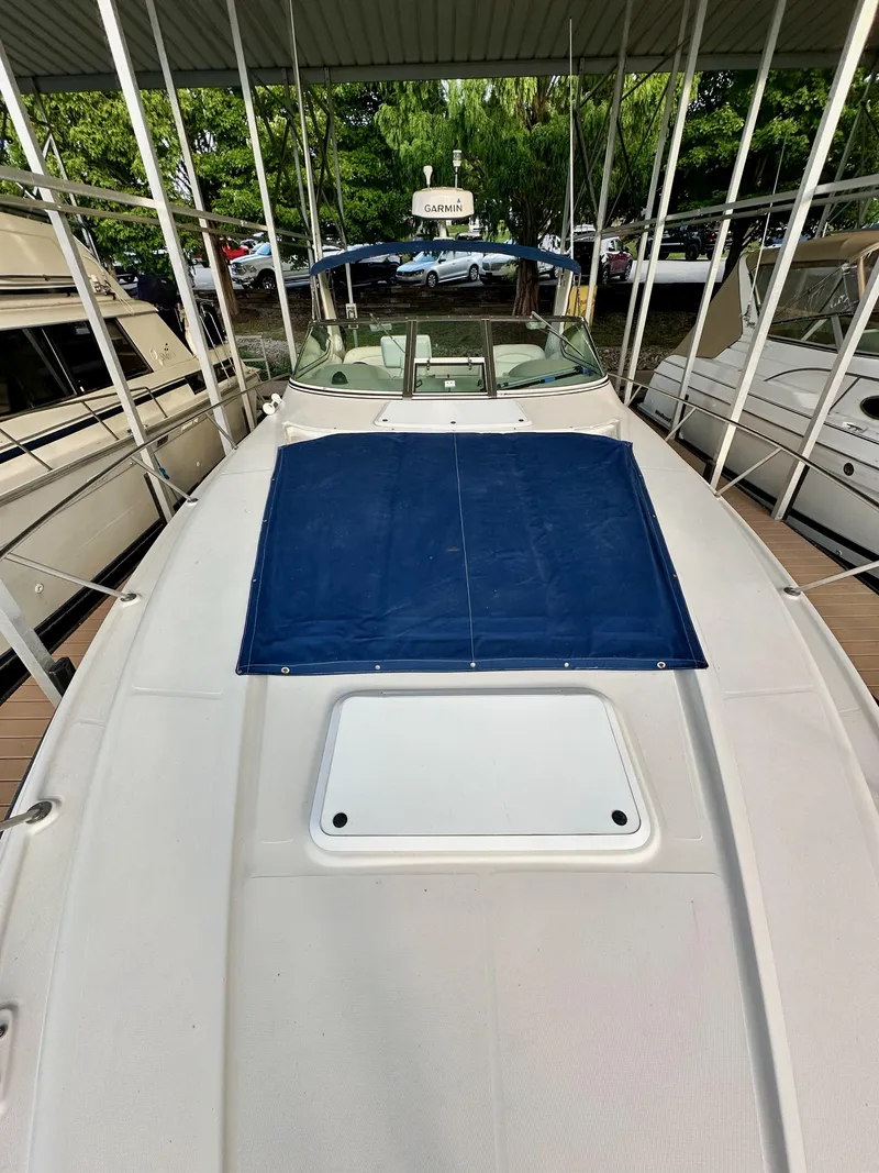 Slide: The Image of 1997 Regal Commodore 402 boat docked, featuring a blue cover and Garmin equipment. - 17