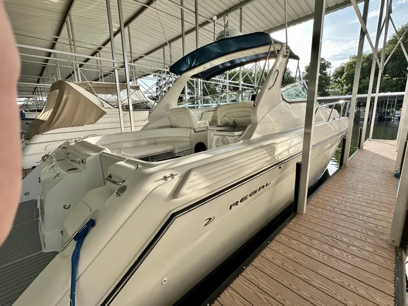 Slide: The Image of 1997 Regal Commodore 402 yacht docked in a covered marina, showcasing sleek design and spacious interior. - 3