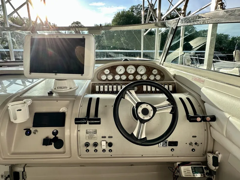 Slide: The Image of Control panel of a 1997 Regal Commodore 402 boat with steering wheel and navigation equipment. - 9