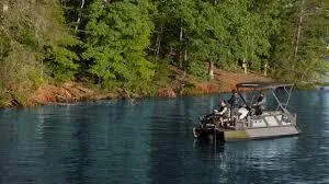 Slide: The Image of 2025 Sea-Doo Switch Fish 21 on a serene lake surrounded by lush trees. - 9