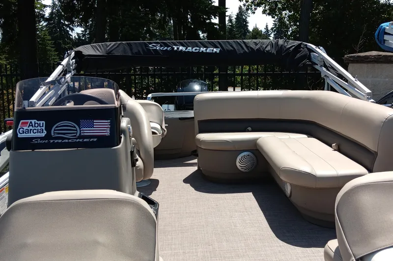 Slide: The Image of 2022 Sun Tracker Bass Buggy 18 DLX pontoon boat interior with seating and canopy. - 2