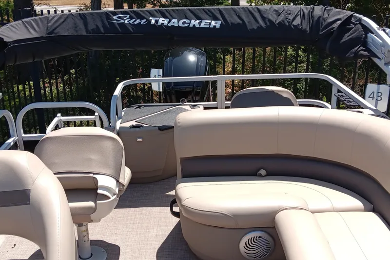 Slide: The Image of 2022 Sun Tracker Bass Buggy 18 DLX pontoon boat interior with seating and canopy. - 4