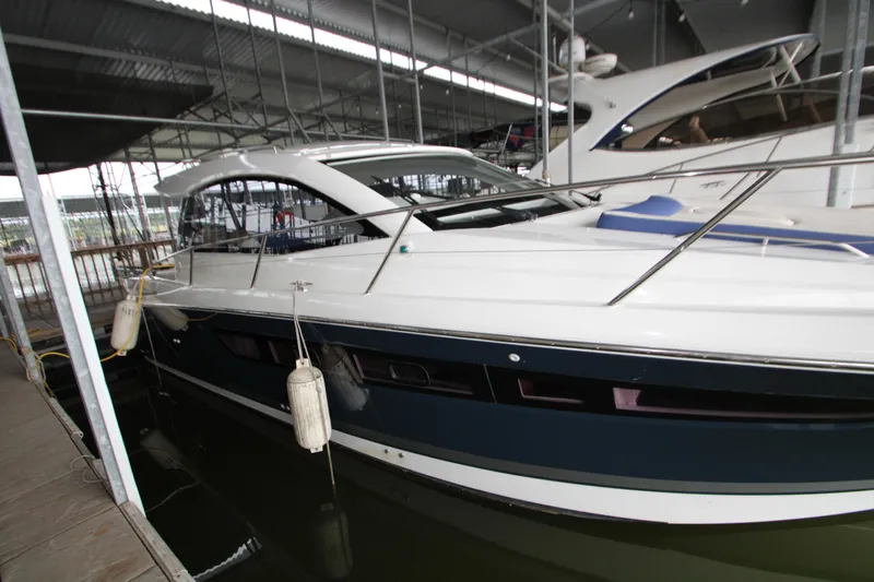 The Image of 2012 Jeanneau Leader 10 yacht docked in a marina under a covered structure. - 0