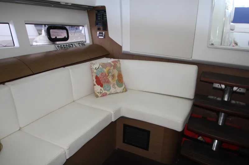Slide: The Image of Interior of 2012 Jeanneau Leader 10 yacht with white seating and floral pillow. - 5