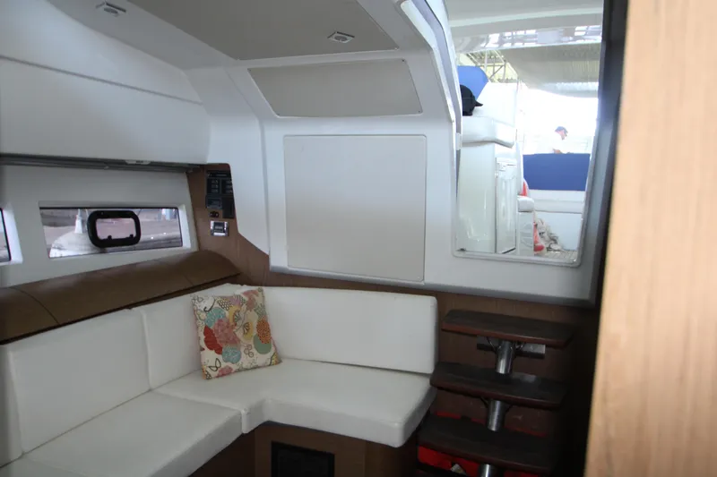 Slide: The Image of Interior of 2012 Jeanneau Leader 10 with white seating and colorful cushions. - 6