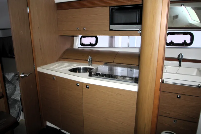 Slide: The Image of Interior of 2012 Jeanneau Leader 10 yacht with white seating and floral cushion. - 7