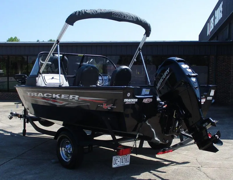 Slide: The Image of 2024 Tracker Pro Guide V-16 WT boat with Mercury engine, parked outdoors. - 3