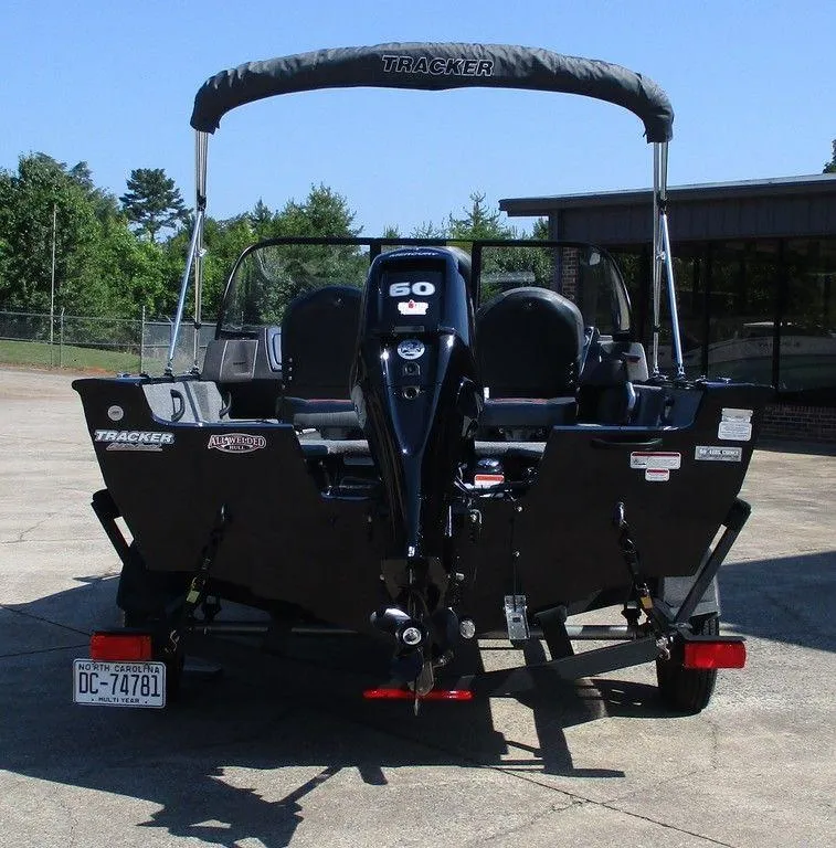 Slide: The Image of 2024 Tracker Pro Guide™ V-16 WT boat with outboard motor, parked outdoors. - 4