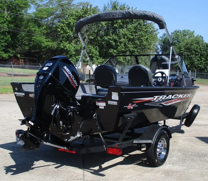 Slide: The Image of 2024 Tracker Pro Guide V-16 WT boat with Mercury engine on trailer, parked outdoors. - 7