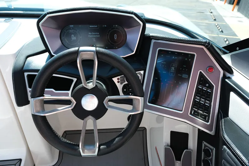 Slide: The Image of 2021 MasterCraft X26 boat dashboard with steering wheel and digital controls. - 17