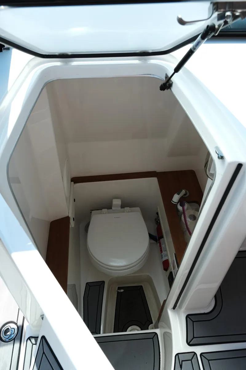Slide: The Image of 2021 MasterCraft X26 boat interior with compact marine toilet and storage area. - 20