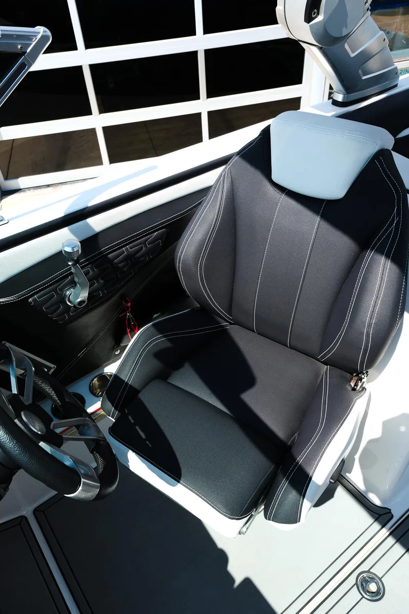 Slide: The Image of 2021 MasterCraft X26 boat interior with black captain's seat and steering wheel. - 21