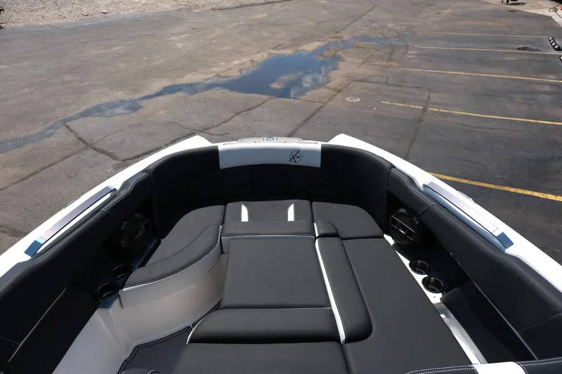 Slide: The Image of 2021 MasterCraft X26 boat interior with black seating and cup holders. - 28
