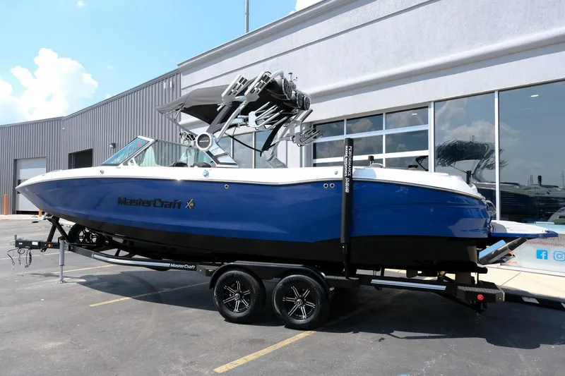 Slide: The Image of 2021 MasterCraft X26 boat in blue on a trailer outside a showroom. - 3
