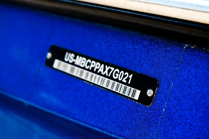 Slide: The Image of Close-up of a 2021 MasterCraft X26 boat identification plate on a blue surface. - 38