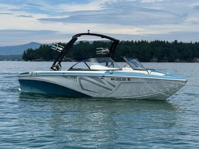 Slide: The Image of 2019 Tigé R21 boat on a lake with scenic forested background. - 1