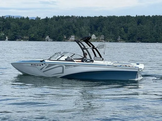 Slide: The Image of 2019 Tigé R21 boat on a lake with forested shoreline in the background. - 11