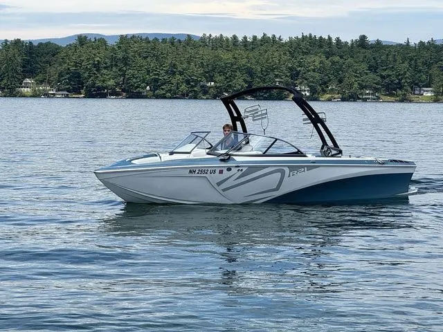 Slide: The Image of 2019 Tigé R21 boat on a serene lake with forested shoreline. - 12