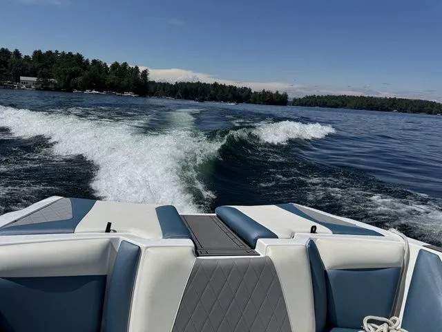 Slide: The Image of 2019 Tigé R21 boat cruising on a lake, leaving a wake behind. - 14