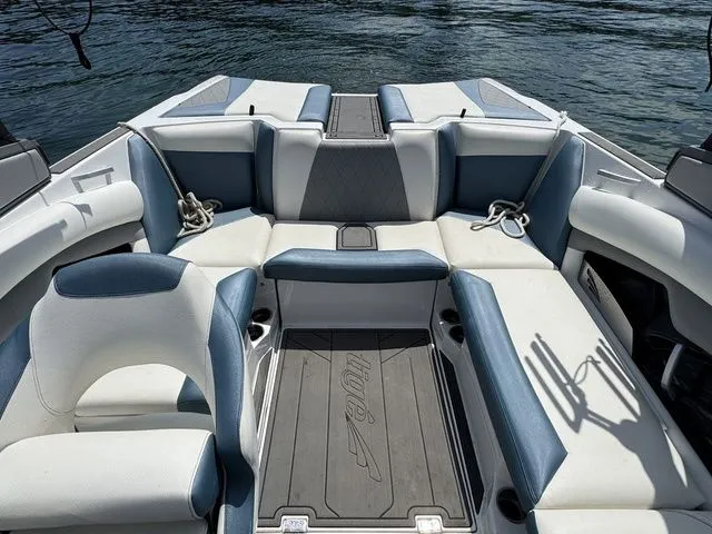 Slide: The Image of 2019 Tigé R21 boat interior with blue and white seating, on a calm water background. - 19