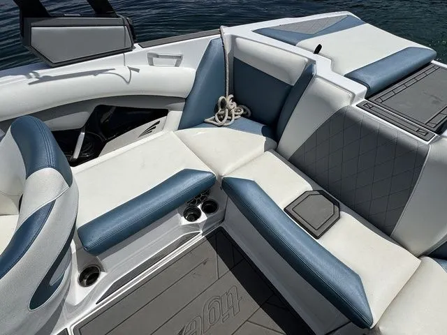 Slide: The Image of 2019 Tigé R21 boat interior with blue and white seating, cup holders, and rope. - 20