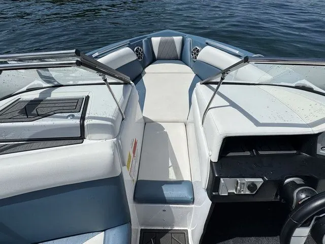 Slide: The Image of 2019 Tigé R21 boat interior with white and blue seating, on calm water. - 25
