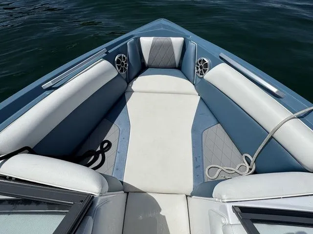Slide: The Image of 2019 Tigé R21 boat interior with blue and white seating, on calm water. - 26