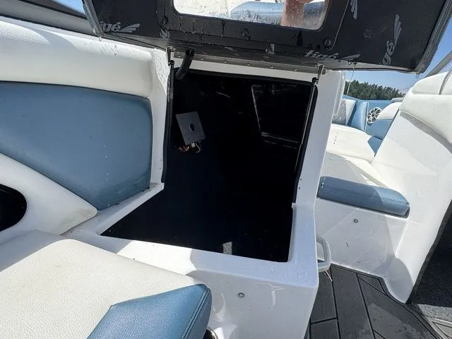 Slide: The Image of 2019 Tigé R21 boat interior with open storage compartment, featuring white and blue seating. - 27