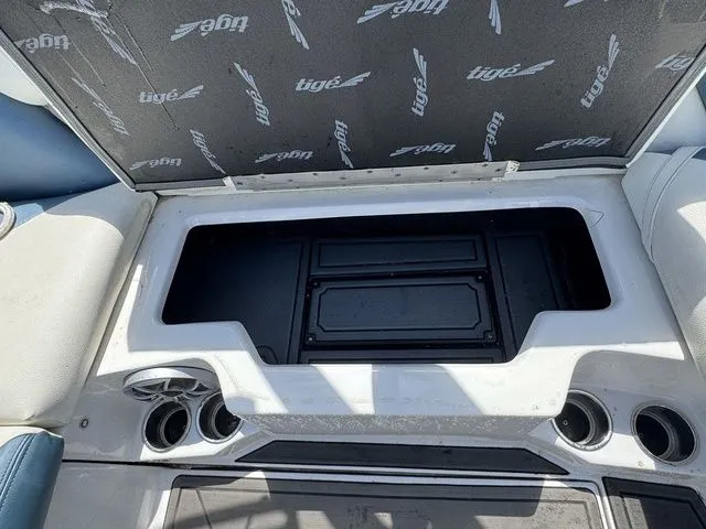 Slide: The Image of 2019 Tigé R21 boat interior storage compartment with cup holders and branded upholstery. - 28