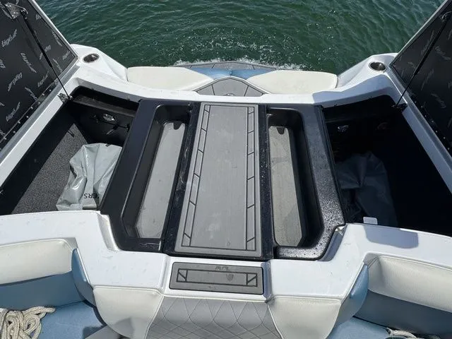 Slide: The Image of 2019 Tigé R21 boat interior with open storage compartments on a sunny day. - 29