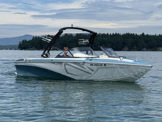 Slide: The Image of 2019 Tigé R21 boat on a lake with scenic forested background. - 3