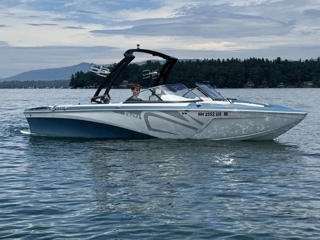 Slide: The Image of 2019 Tigé R21 boat on a lake with scenic forested background. - 4