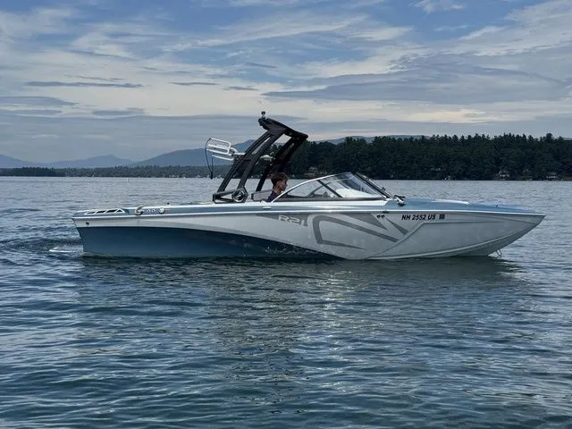 Slide: The Image of 2019 Tigé R21 boat cruising on a calm lake under a cloudy sky. - 5