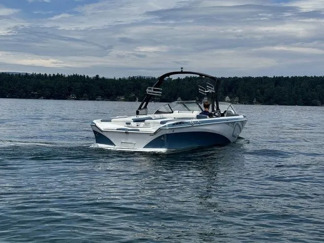 Slide: The Image of 2019 Tigé R21 boat cruising on a serene lake under a cloudy sky. - 7
