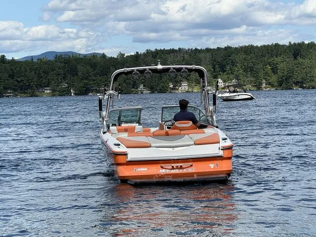 Slide: The Image of 2012 MasterCraft X-35 boat on a lake, surrounded by trees and mountains. - 10