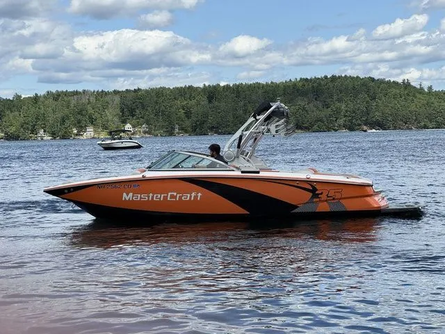 Slide: The Image of 2012 MasterCraft X-35 boat on a lake with scenic forest background. - 11