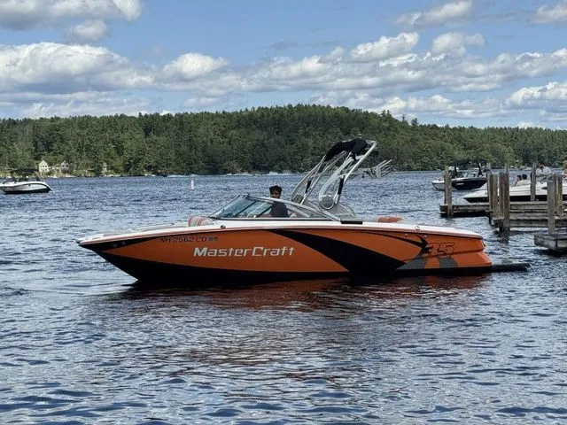 Slide: The Image of 2012 MasterCraft X-35 boat on a lake with scenic forest background. - 12