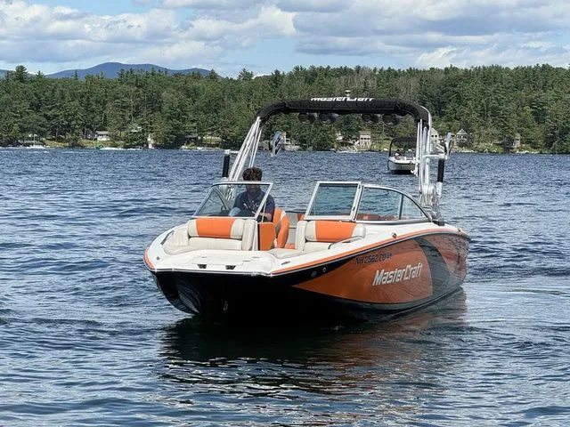 Slide: The Image of 2012 MasterCraft X-35 boat on a lake with scenic forested background. - 13