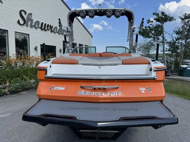 Slide: The Image of 2012 MasterCraft X-35 boat, orange and white, parked outside showroom. - 22
