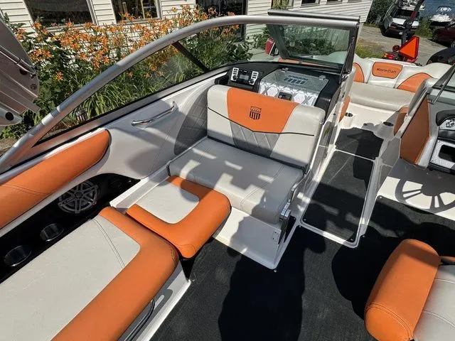 Slide: The Image of 2012 MasterCraft X-35 boat interior with orange and white seating, sleek design, and modern dashboard. - 28