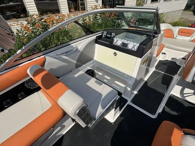 Slide: The Image of 2012 MasterCraft X-35 boat interior with orange and white seating, dashboard, and floral background. - 29