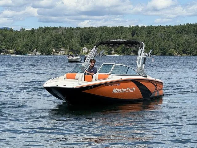Slide: The Image of 2012 MasterCraft X-35 boat on a lake with a person onboard, surrounded by trees. - 3